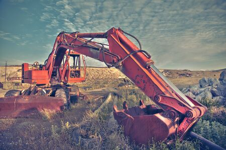 track-type loader excavator machine doing earth moving work at green field