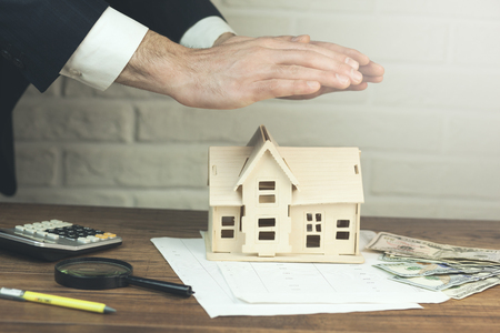 
man hand house model  with calculator and money on tableの写真素材