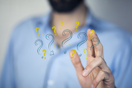 young business man hand question marks on white backgroundの写真素材