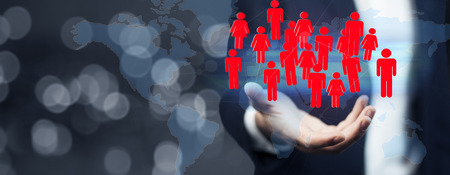 A man's hand holding red human icons, teamwork conceptの写真素材