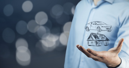 businessman hand holding car and house  in the screenの写真素材