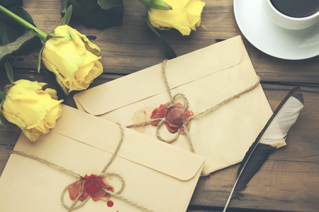 yellow rose with letters  and coffee on tableの写真素材