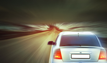 car speeding on a highway at the sunset