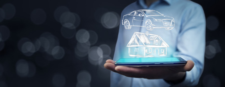 man hand phone with  house and car in  screen in bokeh backgroundの写真素材