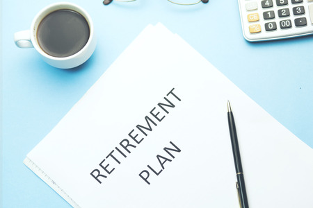retirement plan text on paper with calculator and coffee on table