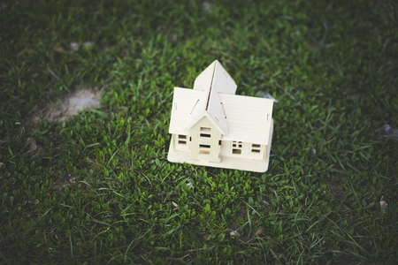 wooden house model on the green grassの写真素材