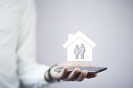 Young businessman hands house phone with houseの写真素材