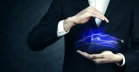 Man hand electric lightning strike, on a dark blue backgroundの写真素材