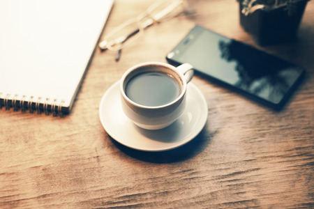 notepad with coffee and phone on wooden table
