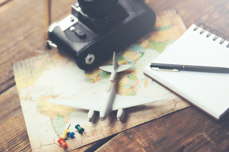 travel accessories: camera, map,airplane with notepad  on wood backgroundの写真素材