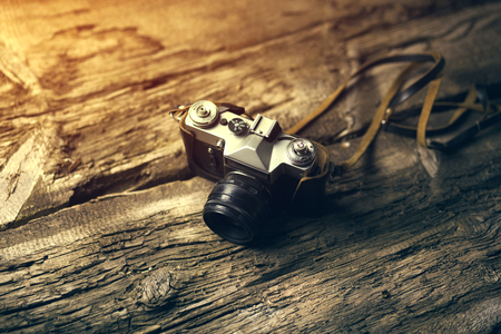 Retro camera on brown wood table backgroundの写真素材