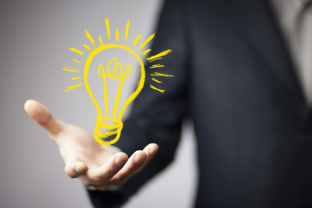 business man touching  a light bulb on touch screenの写真素材