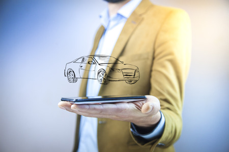 businessman hand phone with car in screenの写真素材