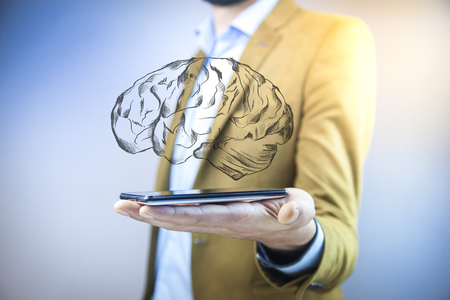 businessman hand phone with brain in screenの写真素材