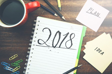 2018 text on notepad with stationary on table