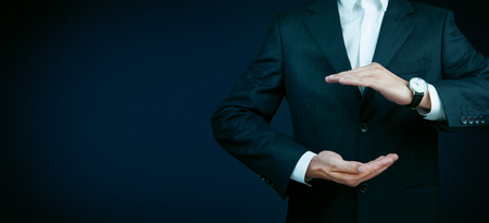 Businessman standing posture show hand isolated on over dark backgroundの写真素材