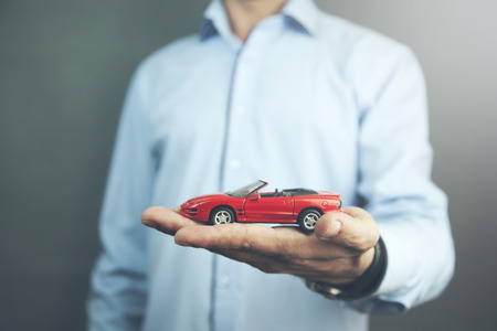 man hand holding a small red carの写真素材