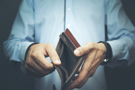 man hand holding an empty wallet in dark background