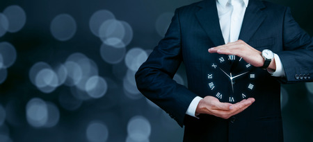 Businessman hand holding a clock time button icon