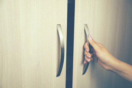 hand of a woman as she is opening a door at nightの写真素材