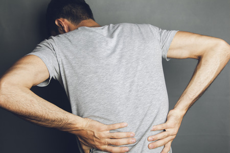 Portrait of the painful back of a young businessmanの写真素材
