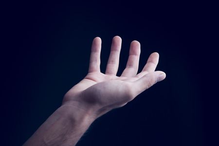 young man empty hand on dark backgroundの写真素材
