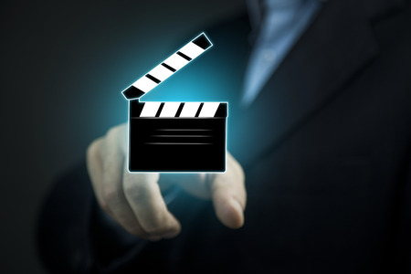 man hand touching a movie clapper slapstickの写真素材