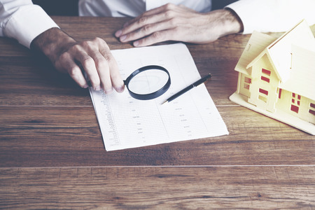 businessman hand magnifier and document with next house modelの写真素材