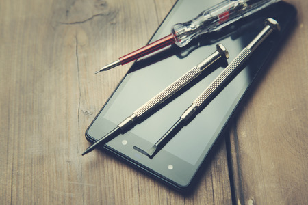 top view of smartphone  and tools over wooden tableの写真素材