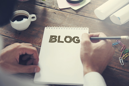 man written blog text on notepad with cup of coffee on tableの写真素材