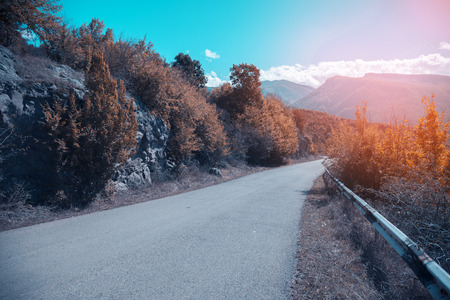 Highway road against mountains at  sunsetの写真素材