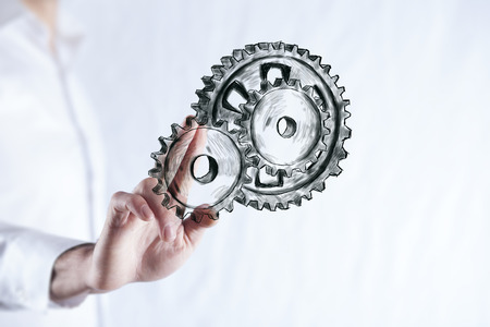 man hand  gears in screen on dark backgroundの写真素材