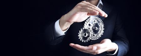 man hand  gears in screen on dark backgroundの写真素材