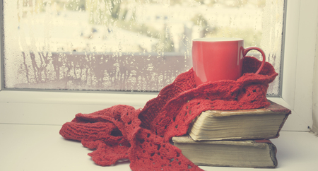 books with cup of coffee on windowの写真素材