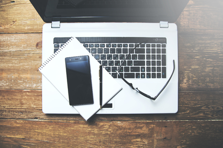 smart phone on notepad on notebook laptopの写真素材