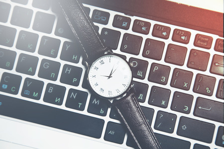 man elegant watch on computer keyboard on tableの写真素材