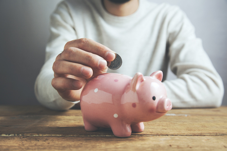 Man putting coin in piggy bank. Saving money conceptの写真素材