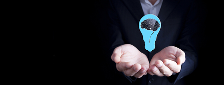 businessman holding an electric light bulbの写真素材