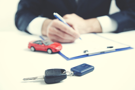 red car and key on businessman handの写真素材
