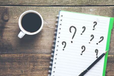 question mark on notepad with coffee cup