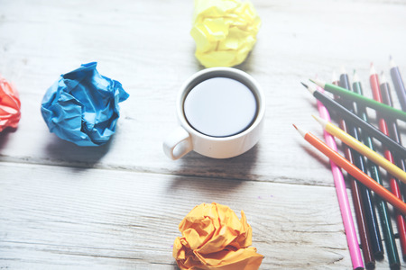 cup of coffee with colorful papers and pencils