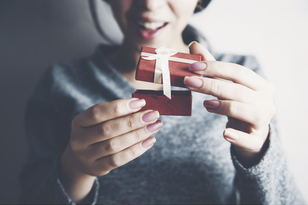 Portrait of a cheerful woman opening gift boxの写真素材