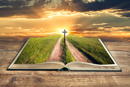 open bible cross in sky at sunsetの写真素材