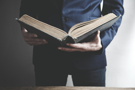 Man reading book on the dark background