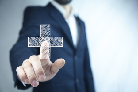 man touching plus or cross sign in screenの写真素材