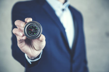 Businessman holding compass showing direction concept for guidanceの写真素材