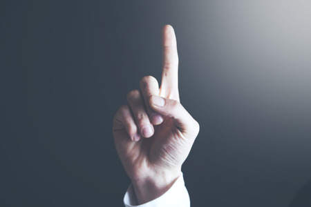 man hand touching his index finger on a gray backgroundの写真素材
