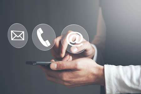 Man hand phone with  contact icons in screenの写真素材