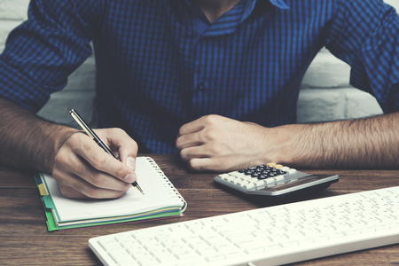 man hand notepad with keyboard on tableの写真素材