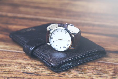 man elegant wallet and watch on wooden tableの写真素材
